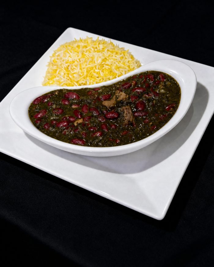 Herb stew with kidney beans and tender filet in a white dish, saffron rice alongside